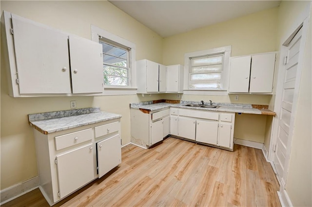 kitchen featuring light hardwood / wood-style flooring, white cabinets, and sink