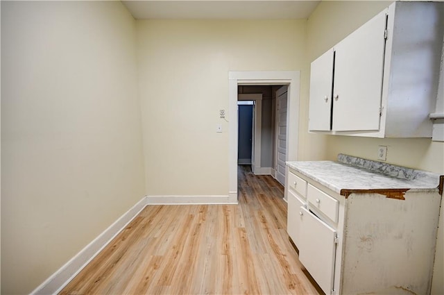 kitchen with light hardwood / wood-style flooring and white cabinets