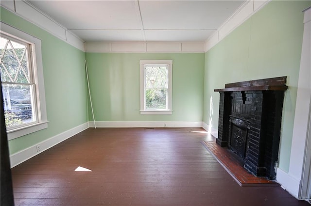 unfurnished living room with a wealth of natural light, dark wood-type flooring, and a fireplace