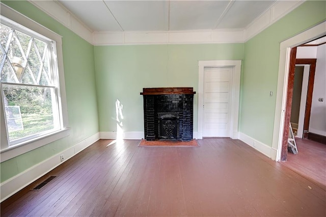 unfurnished living room featuring crown molding, hardwood / wood-style flooring, plenty of natural light, and a fireplace