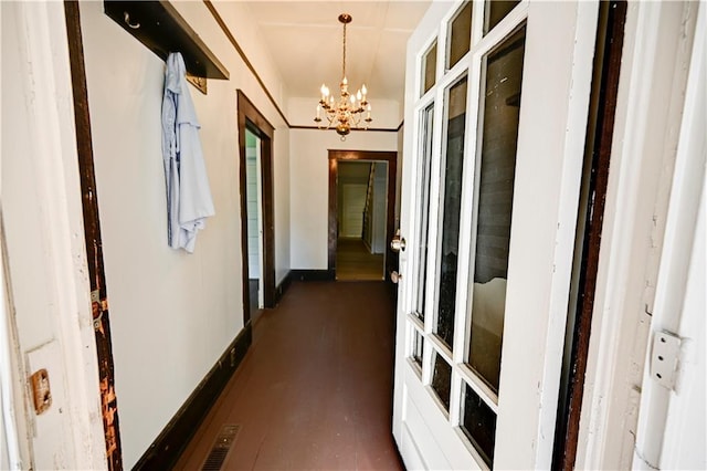 hall featuring an inviting chandelier and dark hardwood / wood-style flooring