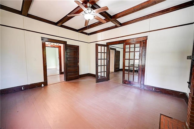 empty room with beam ceiling, french doors, hardwood / wood-style floors, and ceiling fan