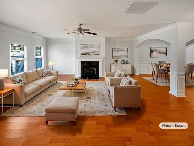 unfurnished living room featuring visible vents, light wood finished floors, ceiling fan, ornamental molding, and a tiled fireplace