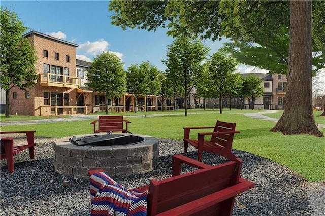 surrounding community featuring a fire pit and a lawn