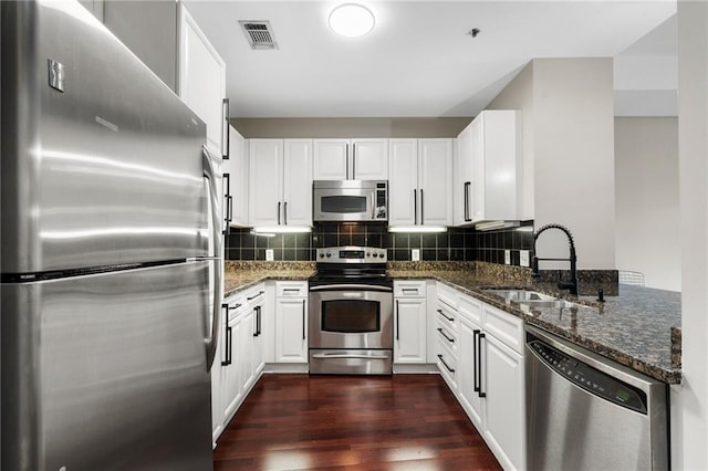 325 E Paces Ferry Rd NE Unit 313, Atlanta, GA 30305 - kitchen with stainless steel appliances, a sink, dark stone countertops, and white cabinetry