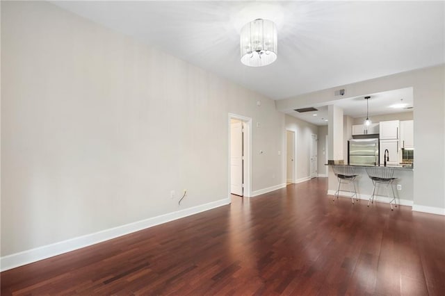 325 E Paces Ferry Rd NE Unit 313, Atlanta, GA 30305 - unfurnished living room featuring dark wood-style floors, a chandelier, and baseboards