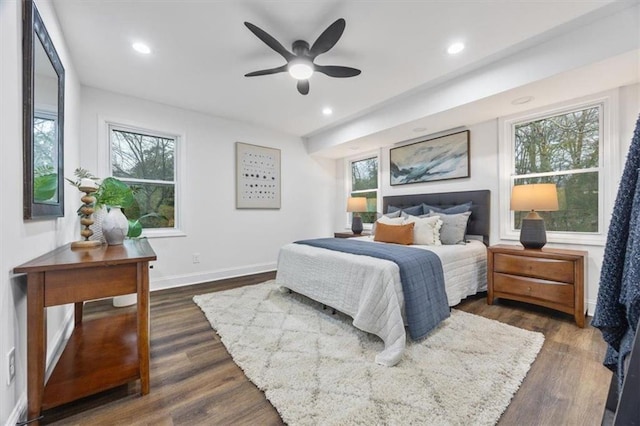 bedroom with multiple windows, dark wood-type flooring, and ceiling fan