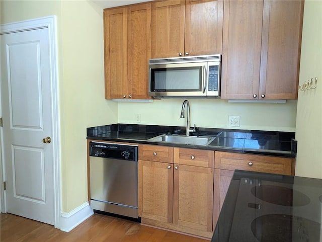57 Forsyth St NW Unit 4H, Atlanta, GA 30303 - kitchen with stainless steel appliances, a sink, dark countertops, and light wood-type flooring