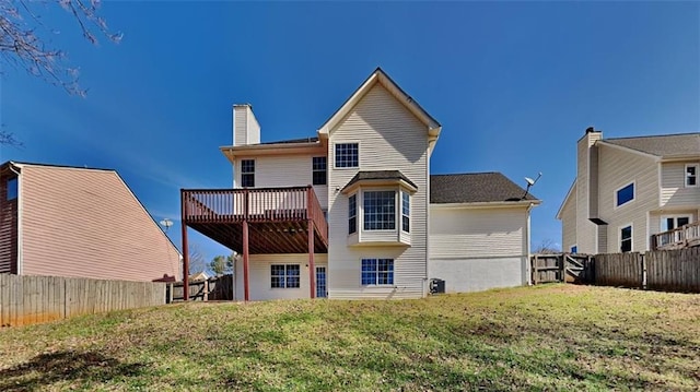 back of house featuring a yard, a deck, a fenced backyard, and a chimney