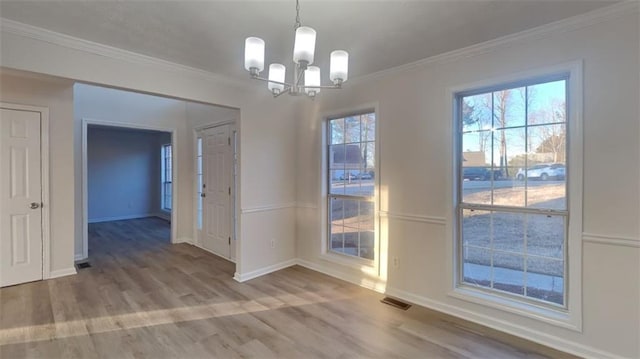 unfurnished dining area with visible vents, crown molding, baseboards, and wood finished floors