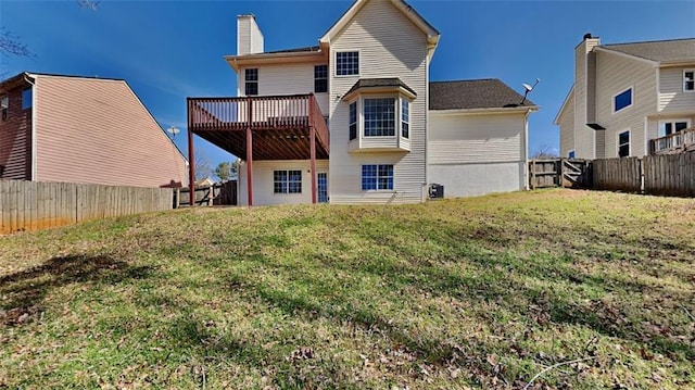 back of property featuring a wooden deck, a lawn, a fenced backyard, and a chimney