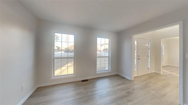 interior space featuring visible vents, light wood-style flooring, and baseboards