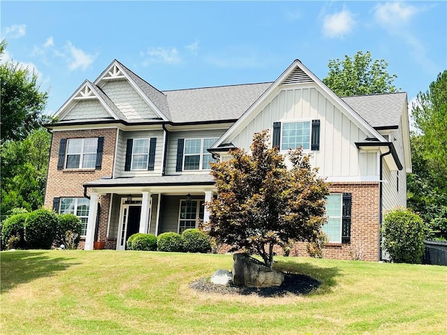 view of front of house featuring brick siding, board and batten siding, and a front yard