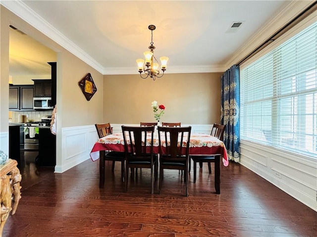 dining space featuring a chandelier, visible vents, ornamental molding, and dark wood-style floors