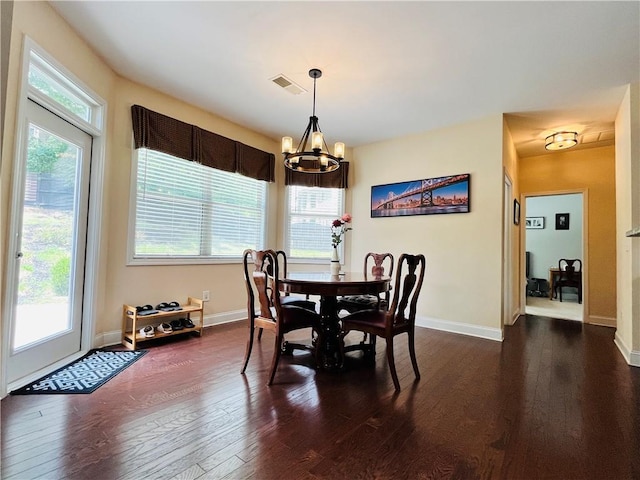 dining space with dark wood-style floors, visible vents, and baseboards