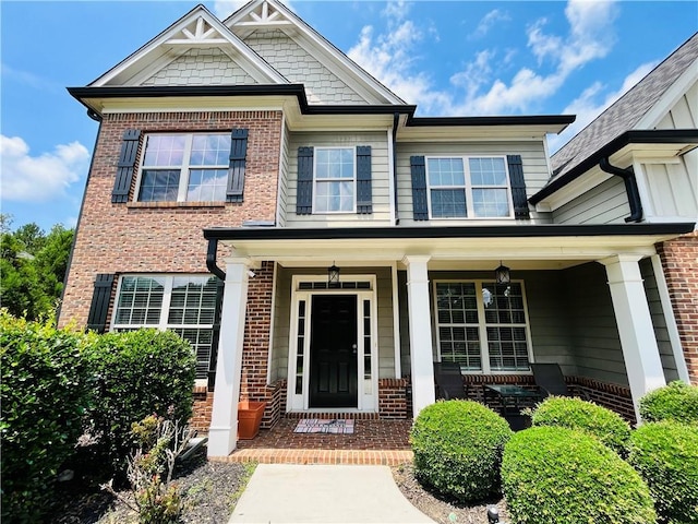 view of front of home featuring covered porch and brick siding