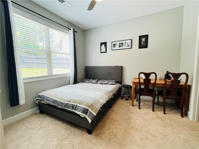 carpeted bedroom with a ceiling fan, visible vents, and baseboards