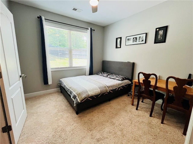 bedroom featuring light carpet, a ceiling fan, visible vents, and baseboards