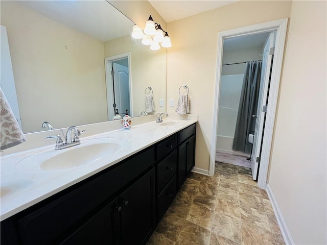 full bath featuring double vanity, baseboards, and a sink