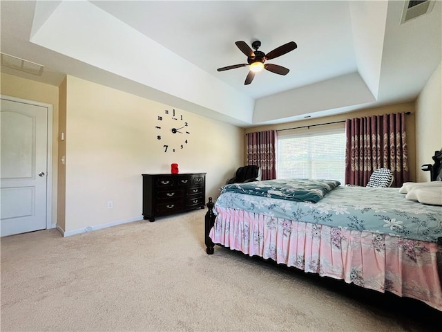 bedroom featuring carpet flooring, a ceiling fan, visible vents, baseboards, and a raised ceiling