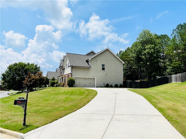 view of home's exterior featuring an attached garage, driveway, fence, and a yard