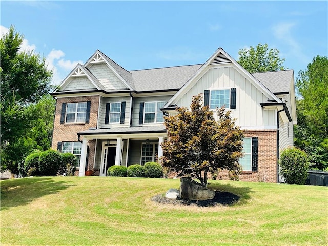 view of front of home featuring brick siding, board and batten siding, and a front yard