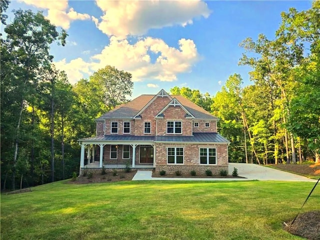 7580 Sunridge Ln, Douglasville, GA 30135 - view of front facade with driveway, a front yard, a standing seam roof, brick siding, and metal roof