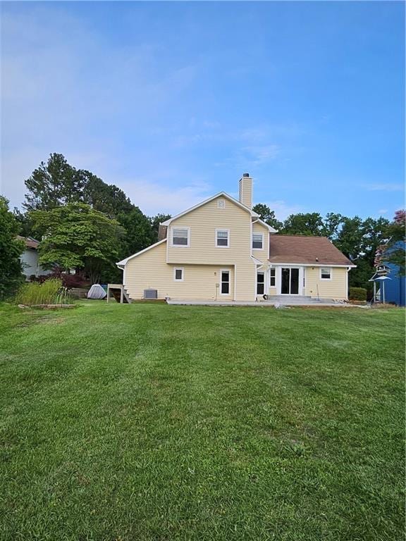 2752 Inverloch Cir, Duluth, GA 30096 - back of property with a chimney, a lawn, and a patio area