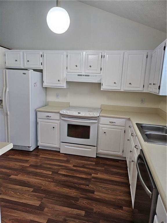 2752 Inverloch Cir, Duluth, GA 30096 - kitchen with white appliances, lofted ceiling, under cabinet range hood, dark wood finished floors, and white cabinetry