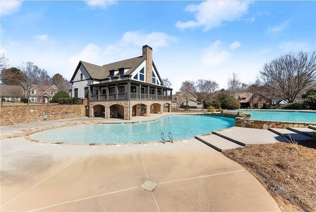 pool with a patio and fence