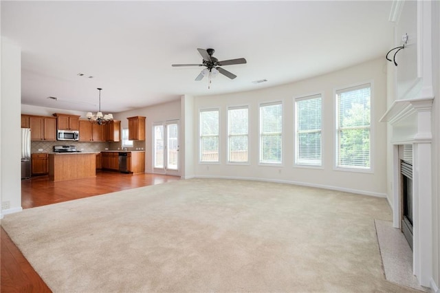 558 Olympic Way, Acworth, GA 30102 - unfurnished living room featuring a chandelier, a fireplace with flush hearth, ceiling fan, and light colored carpet