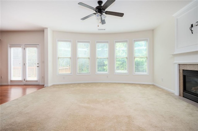 558 Olympic Way, Acworth, GA 30102 - unfurnished living room featuring carpet flooring, a glass covered fireplace, healthy amount of natural light, and a ceiling fan