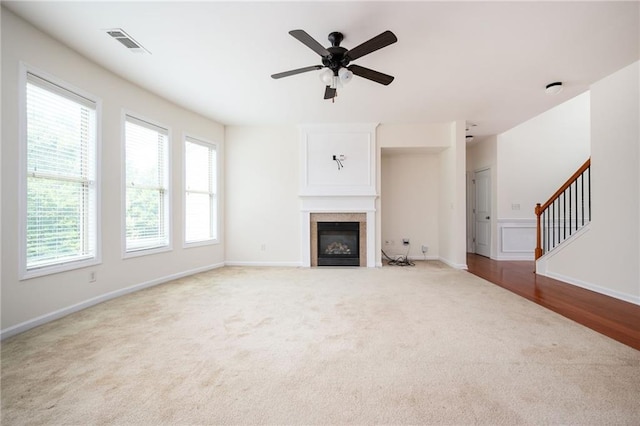 558 Olympic Way, Acworth, GA 30102 - unfurnished living room featuring carpet, a ceiling fan, a glass covered fireplace, and stairs