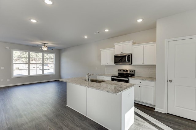 kitchen featuring sink, white cabinetry, appliances with stainless steel finishes, and a center island with sink