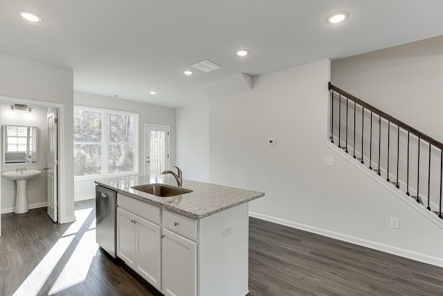 kitchen with white cabinets, an island with sink, sink, light stone counters, and stainless steel dishwasher