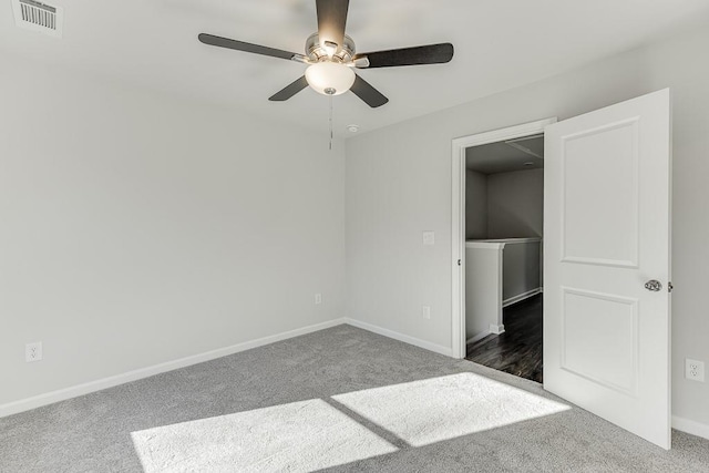 unfurnished bedroom with ceiling fan and dark colored carpet