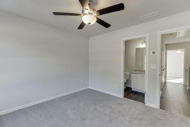 unfurnished bedroom featuring ceiling fan, connected bathroom, and dark colored carpet