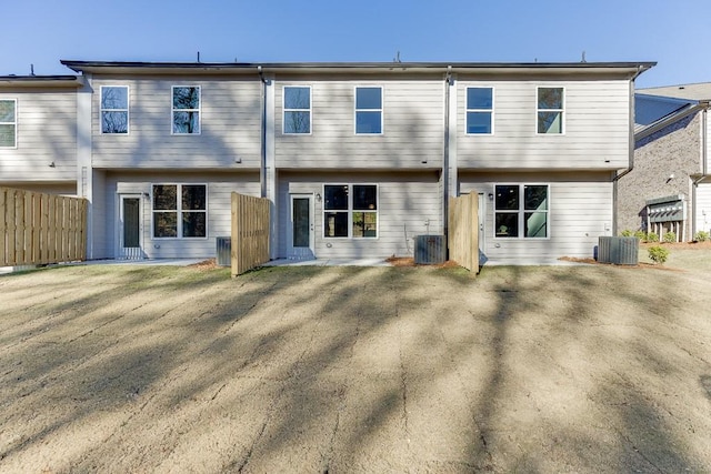 back of property with a lawn and central AC unit