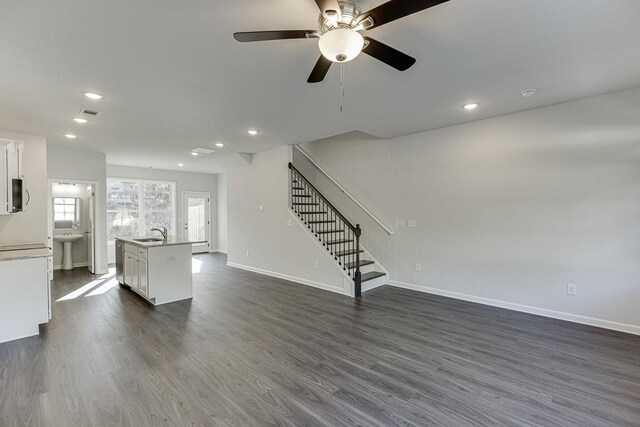 unfurnished living room featuring ceiling fan, dark hardwood / wood-style floors, and sink