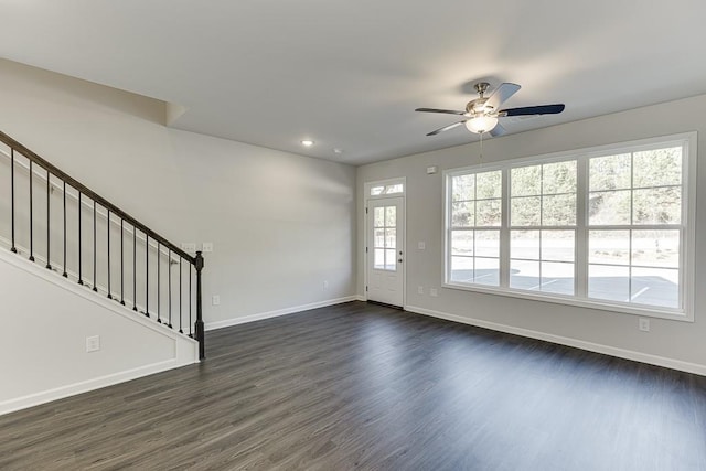 interior space with ceiling fan, a wealth of natural light, and dark hardwood / wood-style flooring