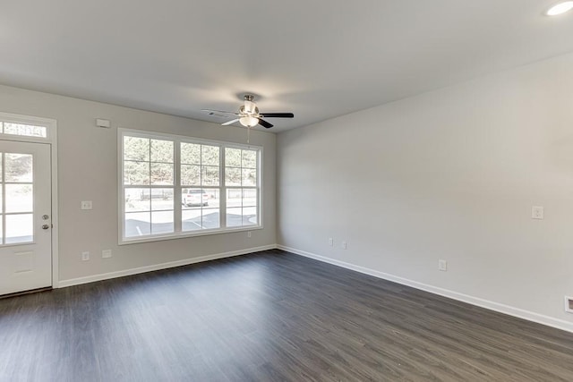 empty room with ceiling fan and dark hardwood / wood-style flooring