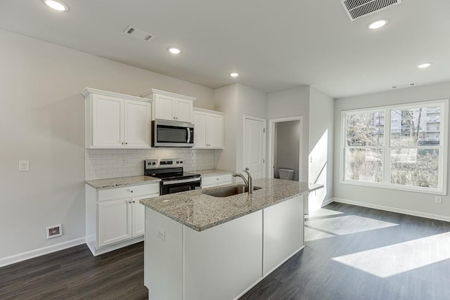 kitchen featuring white cabinets, a kitchen island with sink, sink, and stainless steel appliances