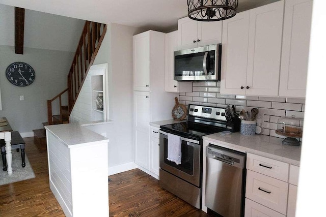 kitchen featuring appliances with stainless steel finishes, tasteful backsplash, white cabinetry, and dark wood-type flooring