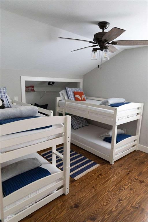 bedroom featuring ceiling fan, lofted ceiling, and dark wood-type flooring