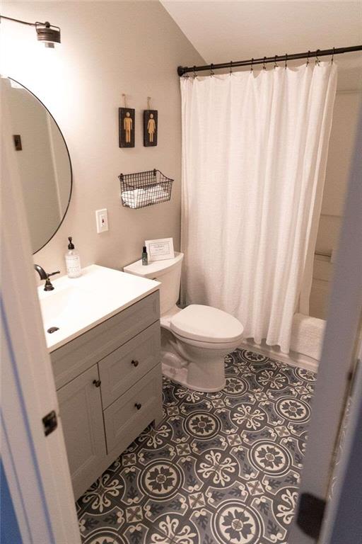bathroom with tile patterned flooring, vanity, and toilet