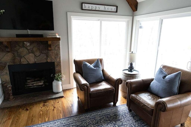 sitting room featuring hardwood / wood-style floors, lofted ceiling with beams, and a fireplace
