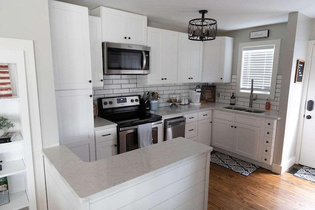 kitchen with pendant lighting, an inviting chandelier, white cabinets, sink, and stainless steel appliances