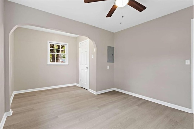 empty room with ceiling fan, electric panel, and light hardwood / wood-style floors