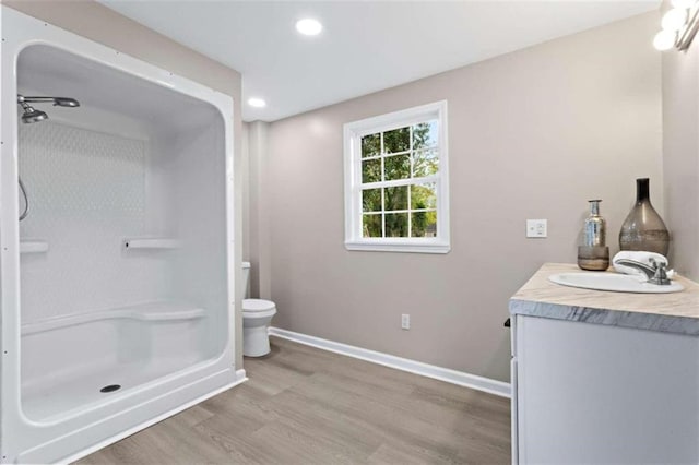 bathroom with vanity, wood-type flooring, toilet, and walk in shower