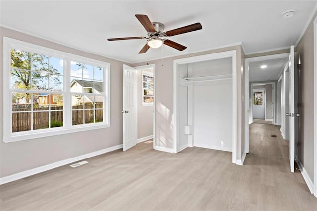 unfurnished bedroom featuring crown molding, ceiling fan, a closet, and light wood-type flooring